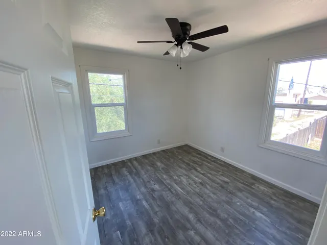 an empty room with a window and a fan