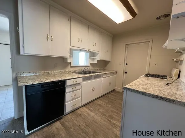 a kitchen with a granite countertop sink stainless steel appliances and cabinets