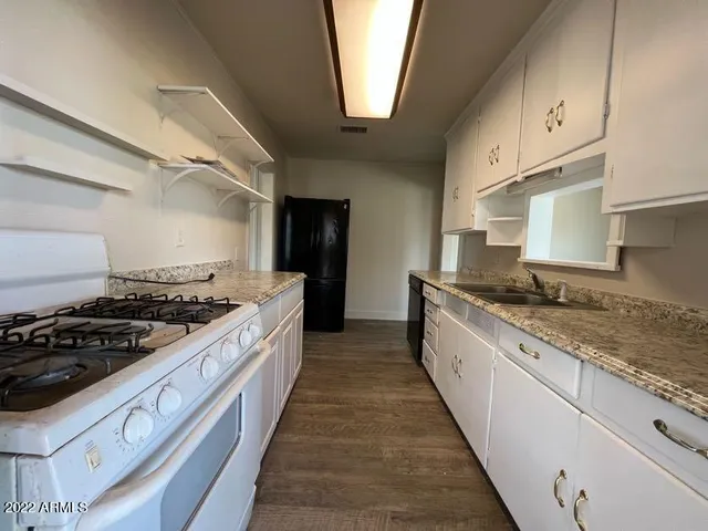 a large kitchen with stainless steel appliances granite countertop a stove and a sink