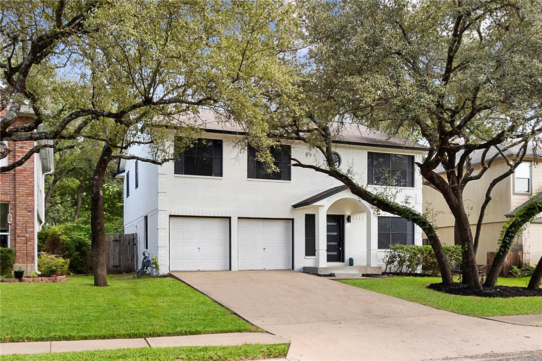 a white house that has a tree in front of it