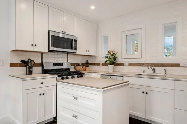 a kitchen with appliances a sink and cabinets