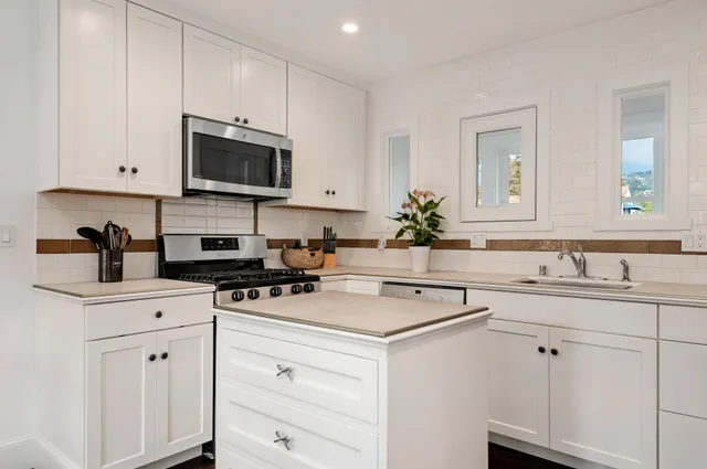 a kitchen with appliances a sink and cabinets