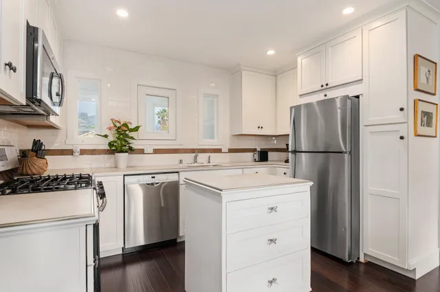 a kitchen with a sink a refrigerator and a stove top oven