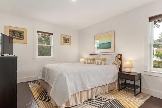 a bedroom with a bed wooden floor and a window