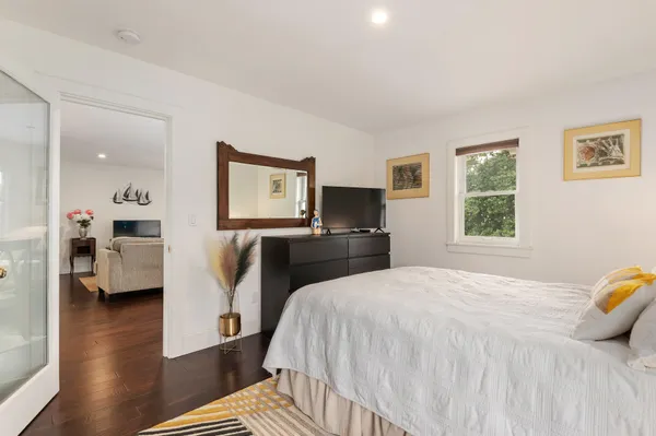 a spacious bedroom with a bed and wooden floor