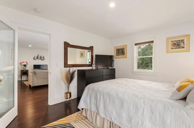 a spacious bedroom with a bed and wooden floor