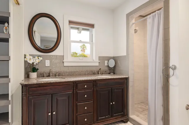 a bathroom with a granite countertop sink a mirror and a window