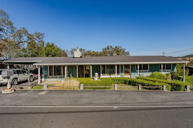 a front view of a house with a garden and plants