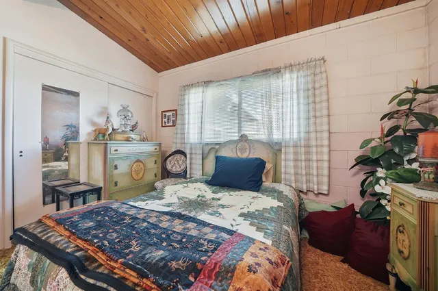 a bed sitting in a bedroom next to a window with bookshelf