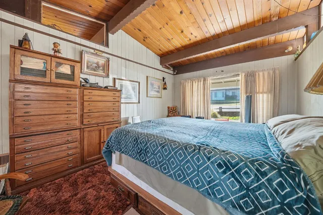 a bed sitting in a spacious bedroom next to a window