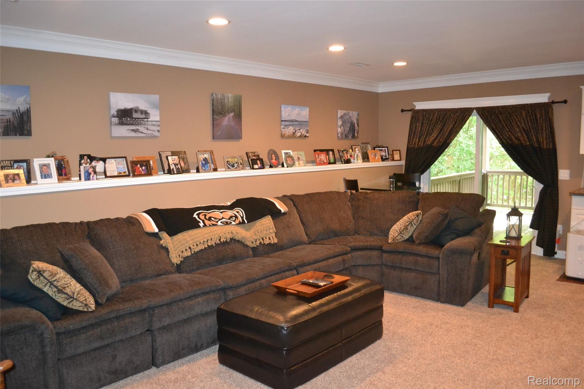 6629 Pond View Road Clarkston, MI 48346 - Photo 34 of 38 Roomy enough for a large sectional. Notice the awesome photo shelf that runs the length of the space! Walk out to an additional deck area where you can enjoy the privacy this condo offers.