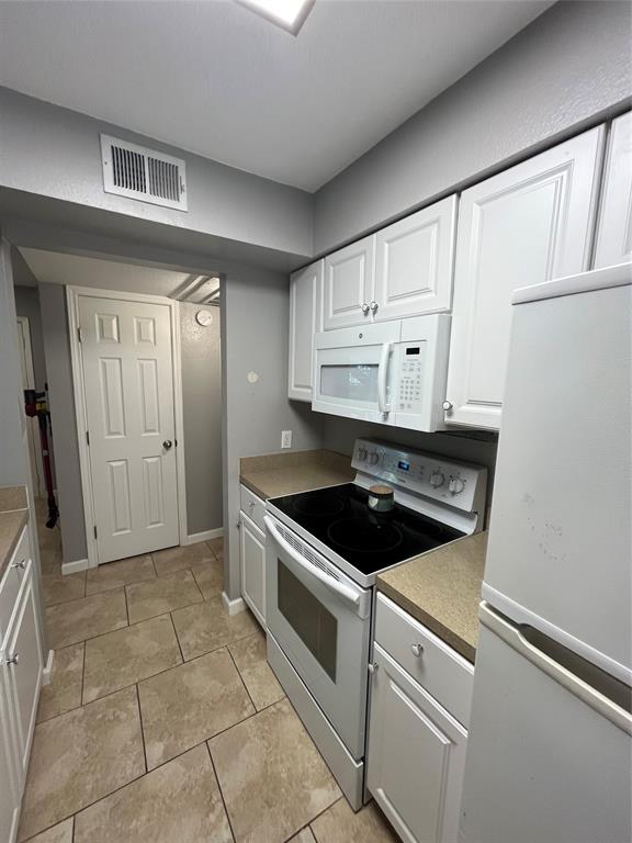1705 Crossing Place, Unit 131 Austin, TX 78741 - Photo 2 of 13 a kitchen with white cabinets and appliances