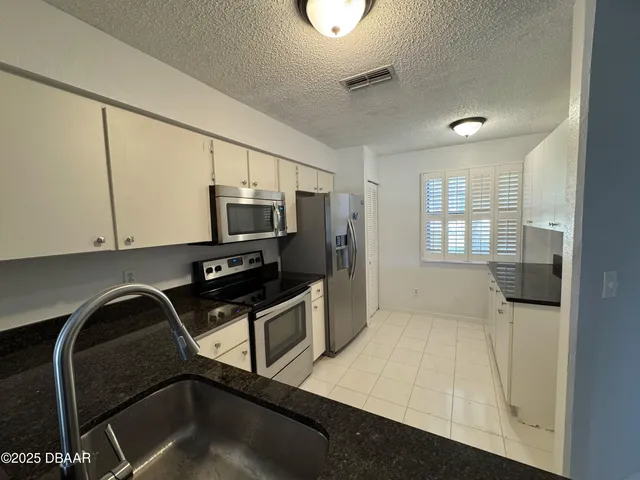 a kitchen with a sink appliances and cabinets