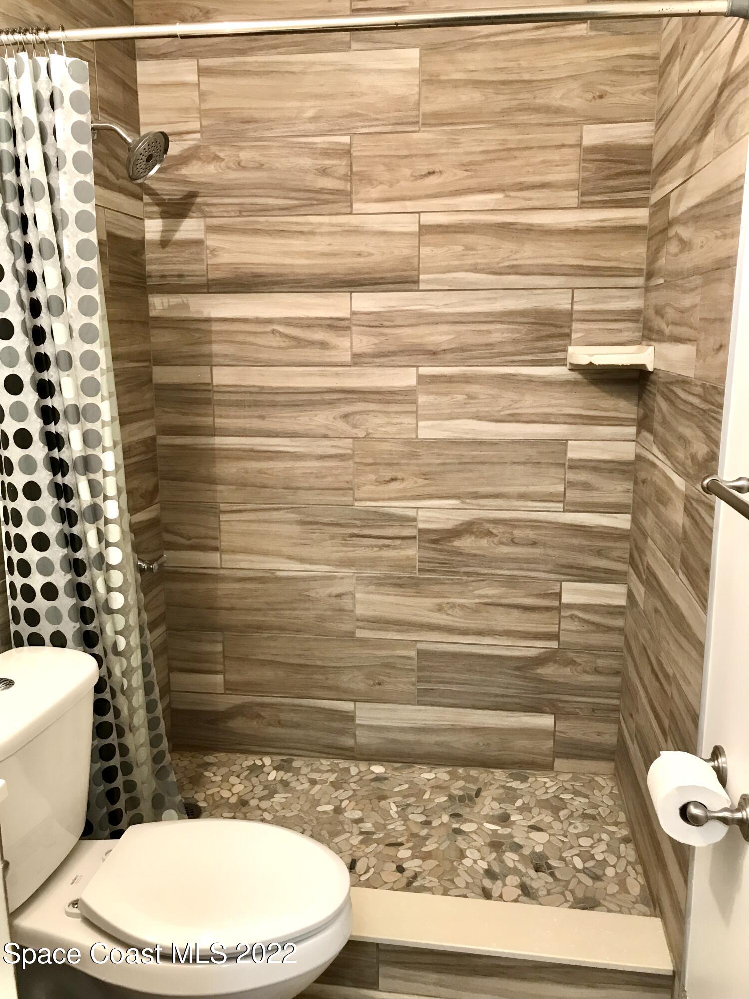 39-41 Patrick Lane, Unit A & B Rockledge, FL 32955 - Photo 9 of 22 a bathroom with a toilet and a shower curtain
