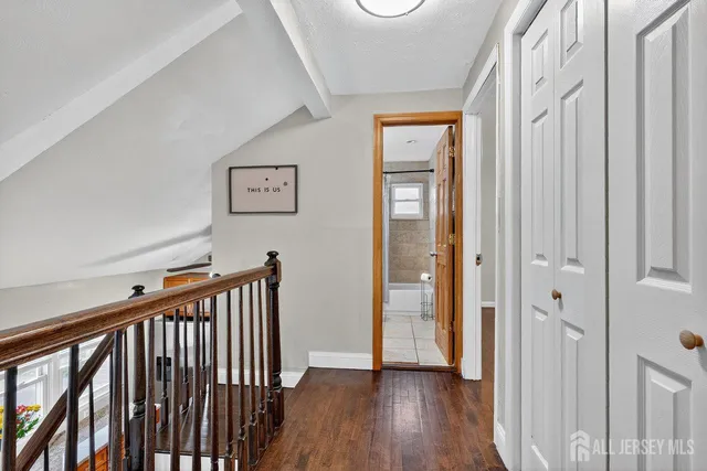 a view of a hallway with wooden floor and stairs