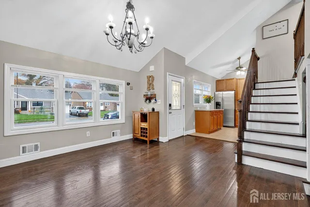 a view of a livingroom with wooden floor and stairs