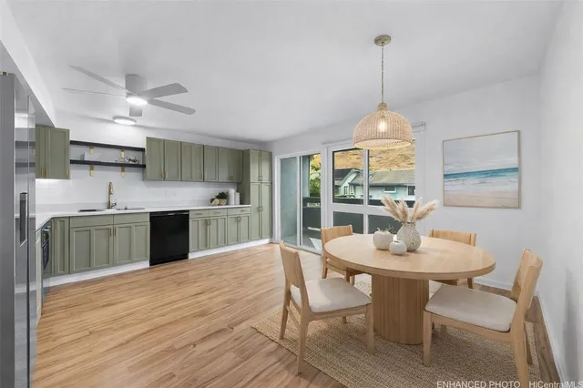 a kitchen with stainless steel appliances kitchen island a table chairs and a wooden floor