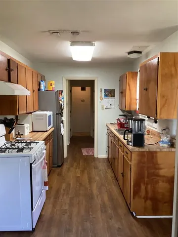 a kitchen with stainless steel appliances granite countertop a stove top oven a sink dishwasher and a refrigerator