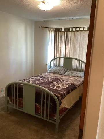 a bed sitting in a bedroom next to a window