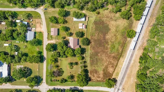 a aerial view of a residential houses with yard and green space