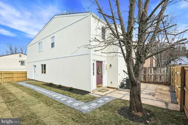 a view of a white house with a large tree