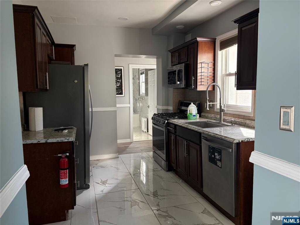 282 Harding Avenue, Unit 1 Teaneck, NJ 07666 - Photo 13 of 21 a kitchen with granite countertop a stove top oven microwave and refrigerator