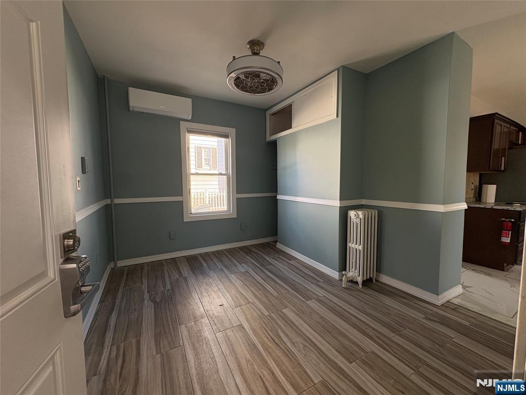 282 Harding Avenue, Unit 1 Teaneck, NJ 07666 - Photo 7 of 21 an empty room with wooden floor and windows