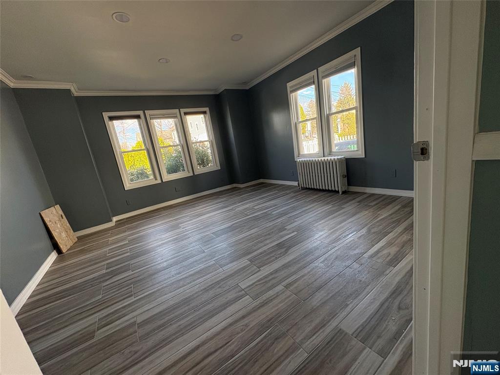 282 Harding Avenue, Unit 1 Teaneck, NJ 07666 - Photo 8 of 21 a view of an empty room with wooden floor and a window