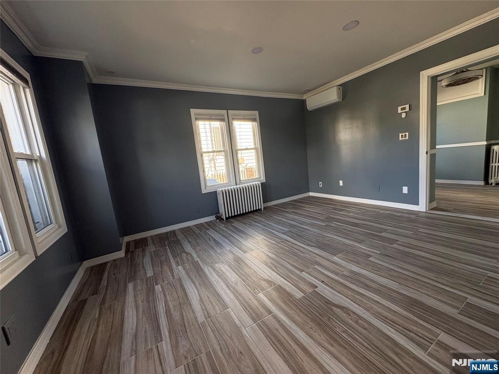 282 Harding Avenue, Unit 1 Teaneck, NJ 07666 - Photo 9 of 21 a view of an empty room with wooden floor and a window