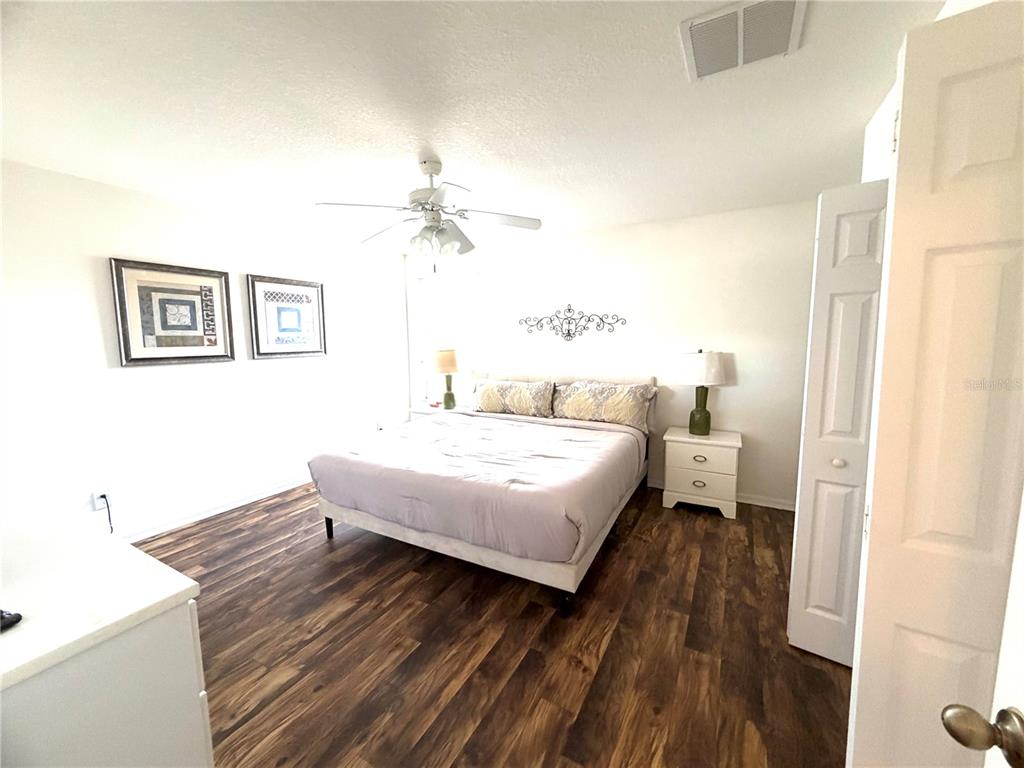 4573 Ada Lane Kissimmee, FL 34746 - Photo 17 of 37 a spacious bedroom with a bed and a table