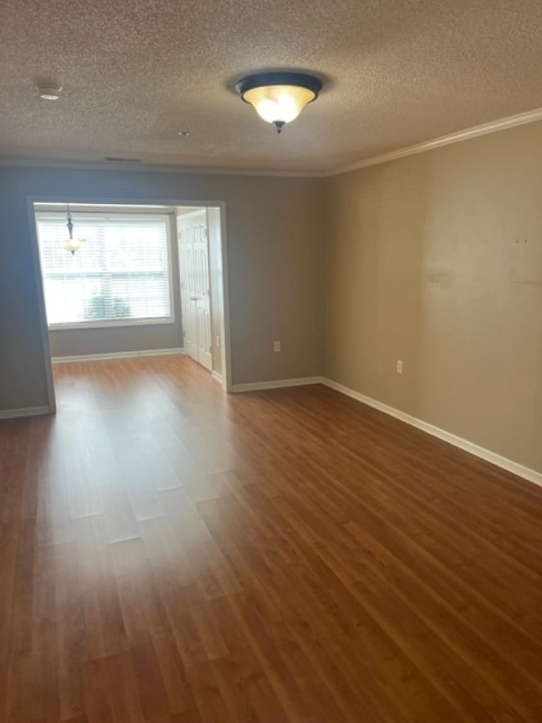 3770 Pardue Woods Place, Unit 103 Raleigh, NC 27603 - Photo 3 of 12 an empty room with wooden floor and windows