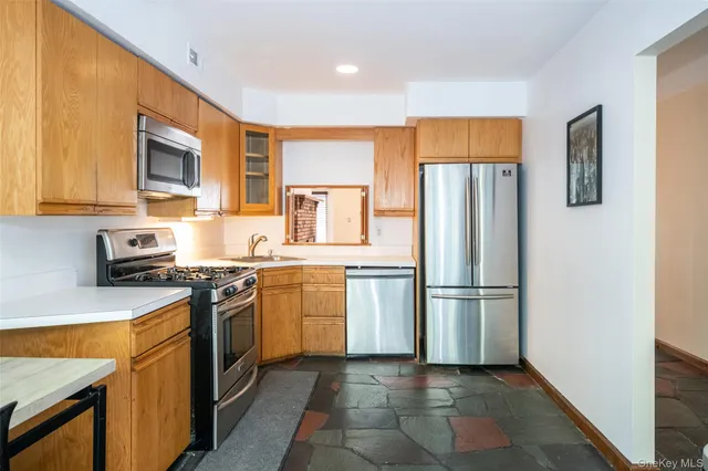 a kitchen with stainless steel appliances granite countertop a refrigerator stove top oven and sink