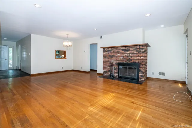 a view of empty room with wooden floor and fireplace