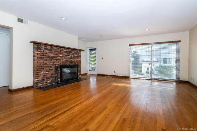 an empty room with wooden floor and fireplace
