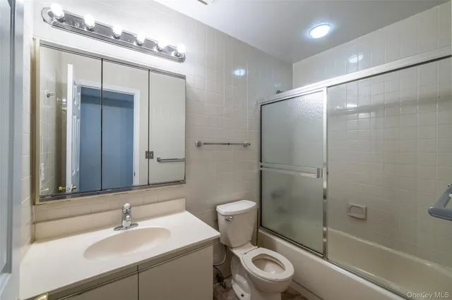 a bathroom with a shower sink vanity mirror and toilet