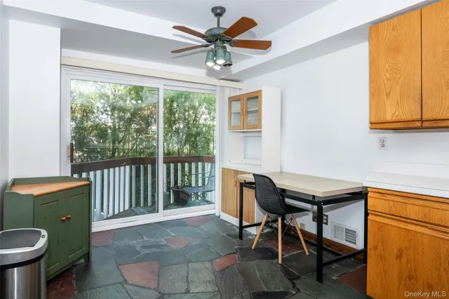 a view of a workspace with furniture and a window