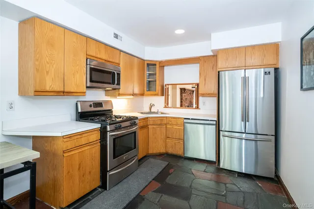 a kitchen with stainless steel appliances granite countertop a refrigerator stove top oven a sink and dishwasher