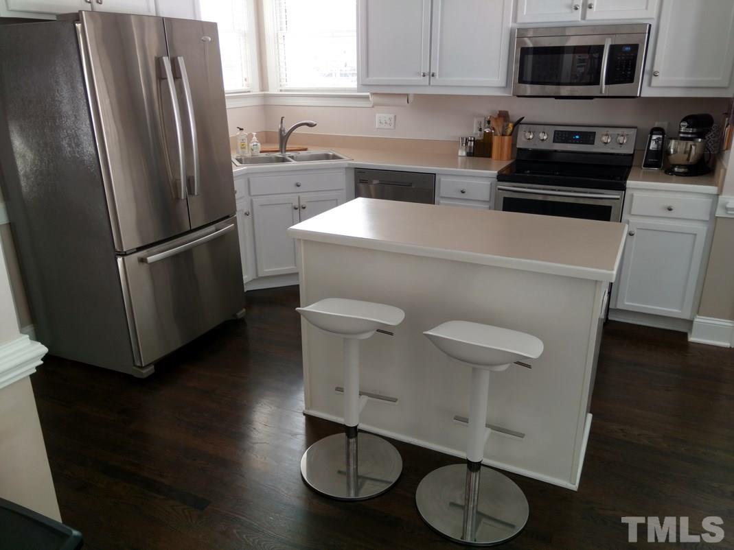 9425 Stone Mountain Road Raleigh, NC 27613 - Photo 11 of 25 a kitchen with a refrigerator sink and cabinets