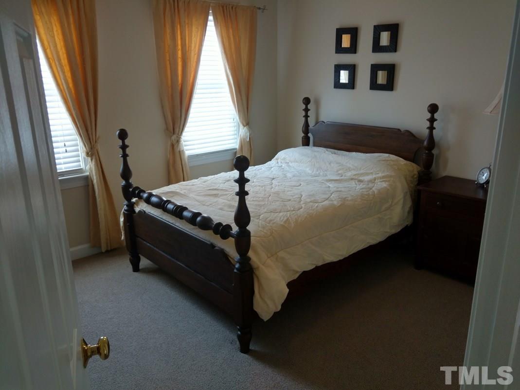 9425 Stone Mountain Road Raleigh, NC 27613 - Photo 15 of 25 a bed sitting in a bedroom next to a window