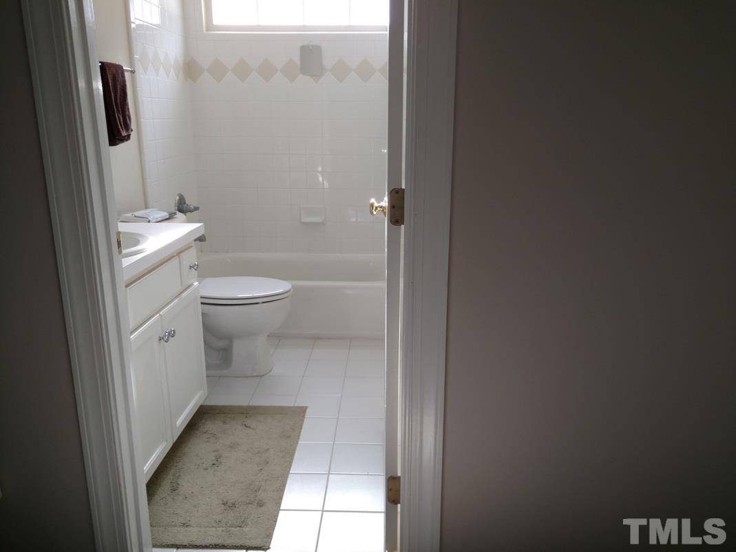 9425 Stone Mountain Road Raleigh, NC 27613 - Photo 18 of 25 a bathroom with a granite countertop toilet and a shower