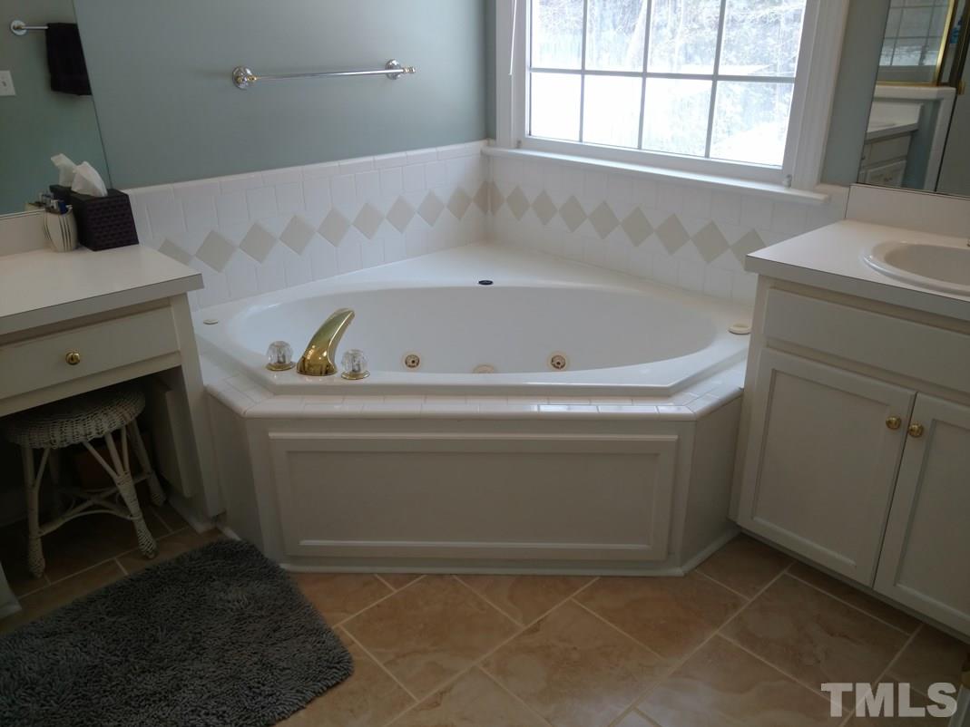 9425 Stone Mountain Road Raleigh, NC 27613 - Photo 24 of 25 a bathroom with a bathtub and a window