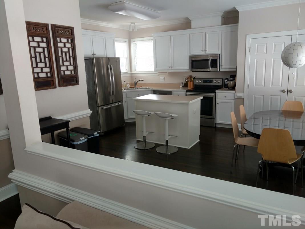 9425 Stone Mountain Road Raleigh, NC 27613 - Photo 10 of 25 a kitchen with a refrigerator and a stove top oven