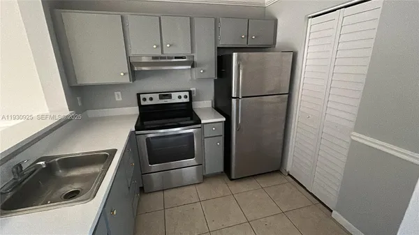 a kitchen with a refrigerator sink and cabinets