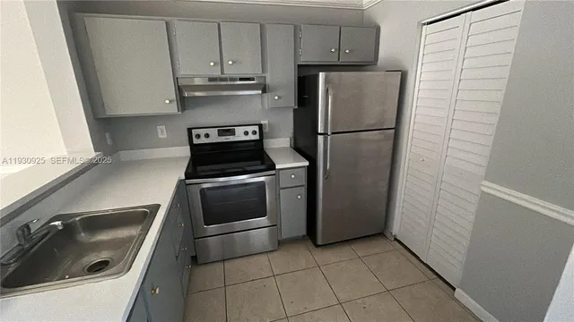 a kitchen with a refrigerator sink and cabinets