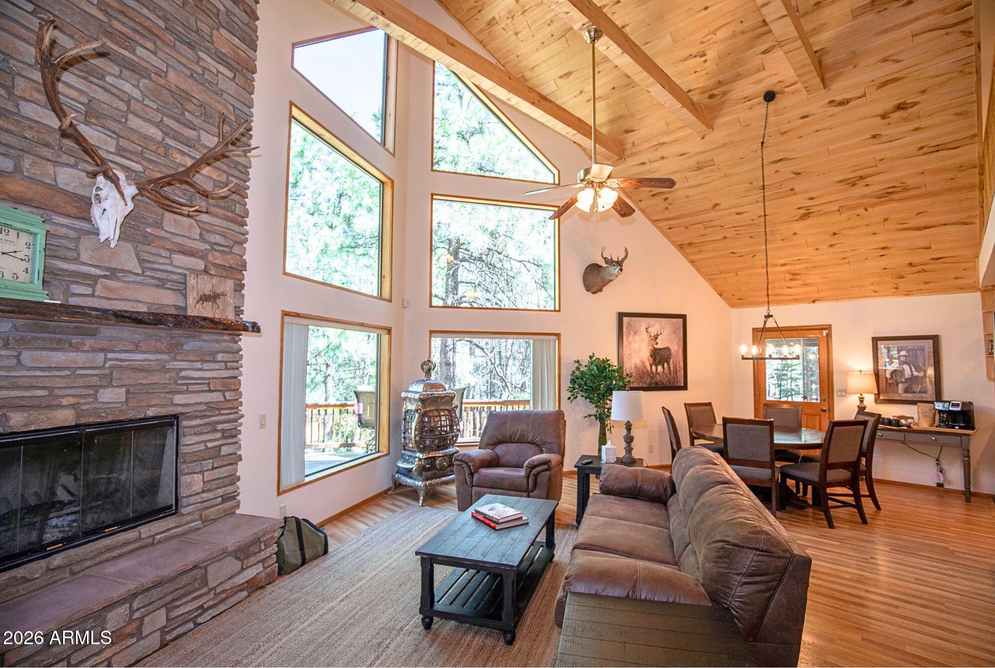 628 Trout Springs Road Forest Lakes, AZ 85931 - Photo 4 of 49 a living room with furniture a fireplace a flat screen tv and windows