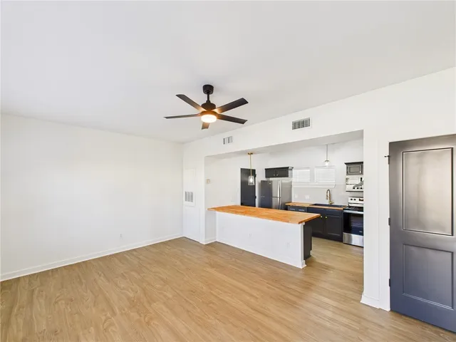 a view of a kitchen with wooden floor and electronic appliances