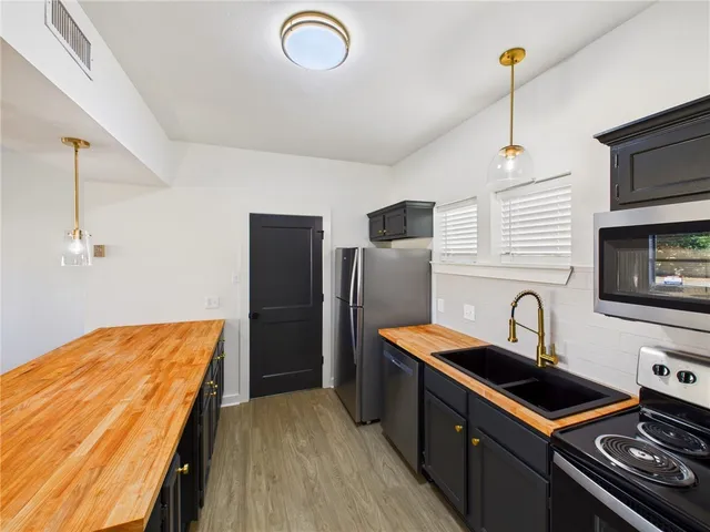 a kitchen with stainless steel appliances granite countertop a sink stove and refrigerator
