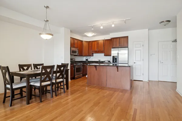 a kitchen with stainless steel appliances a dining table chairs and granite counter tops
