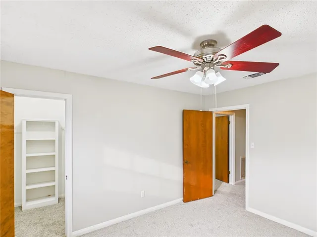 a view of a room with a ceiling fan and a window
