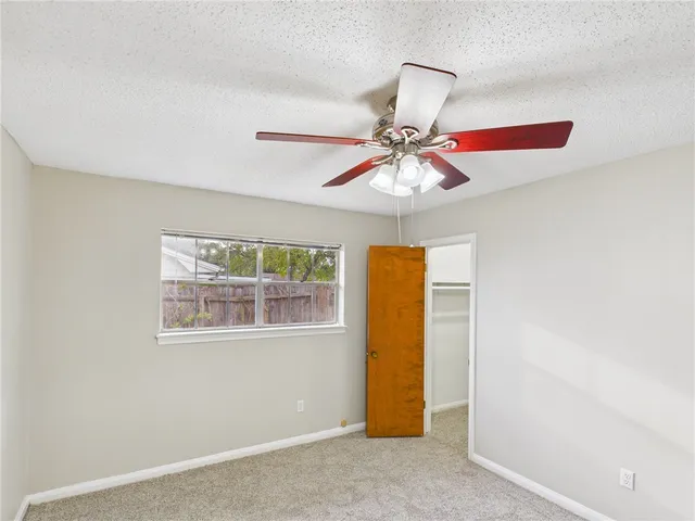 a view of a room with window and ceiling fan